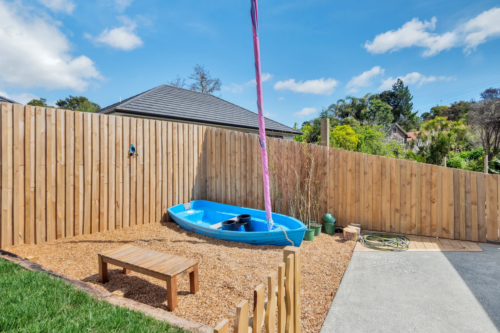 A blue boat set in bark chip for imaginative play