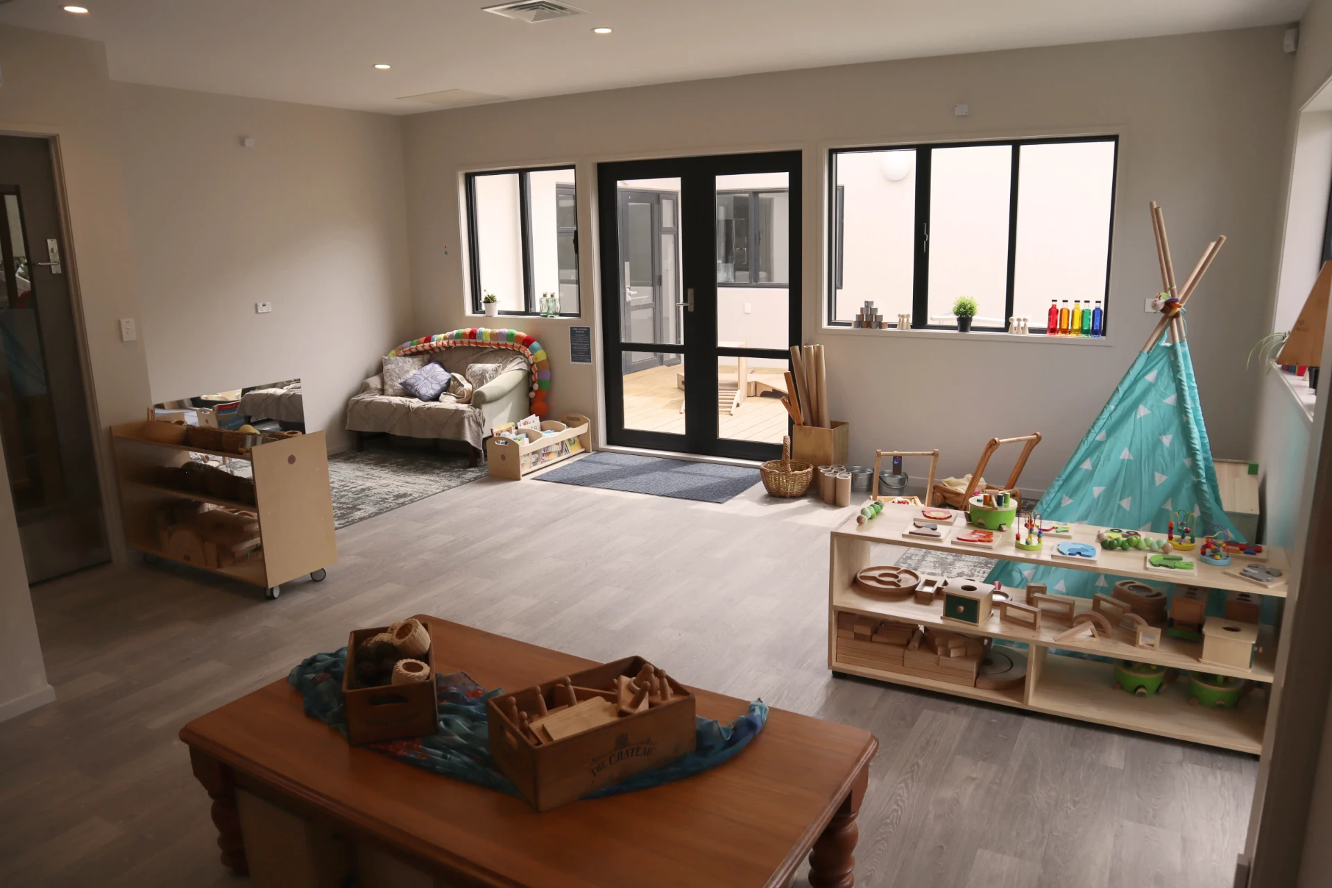 The Bee Room for under twos with wooden toys, a teepee and a cosy reading corner