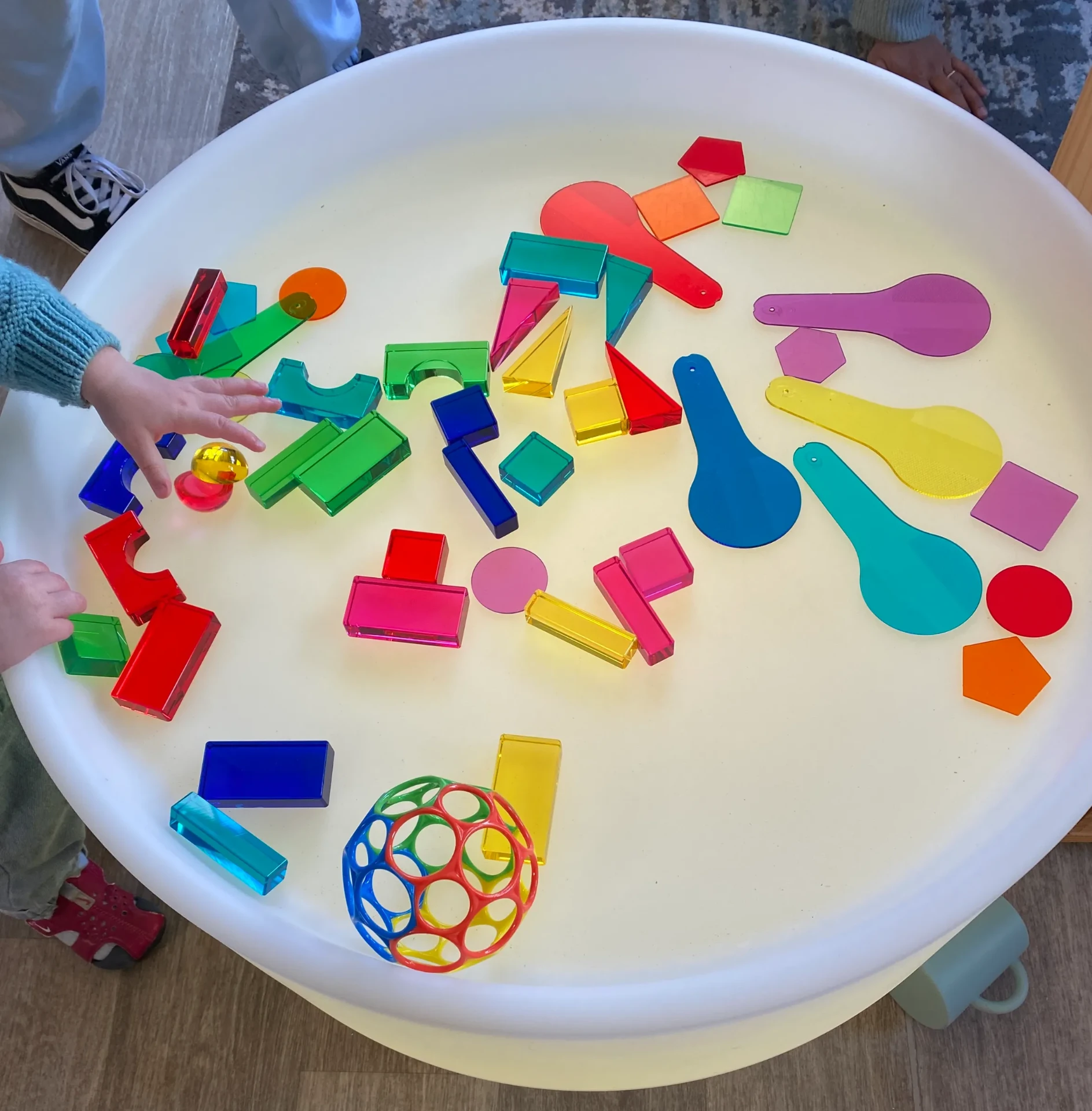 Children exploring translucent coloured blocks on a light table