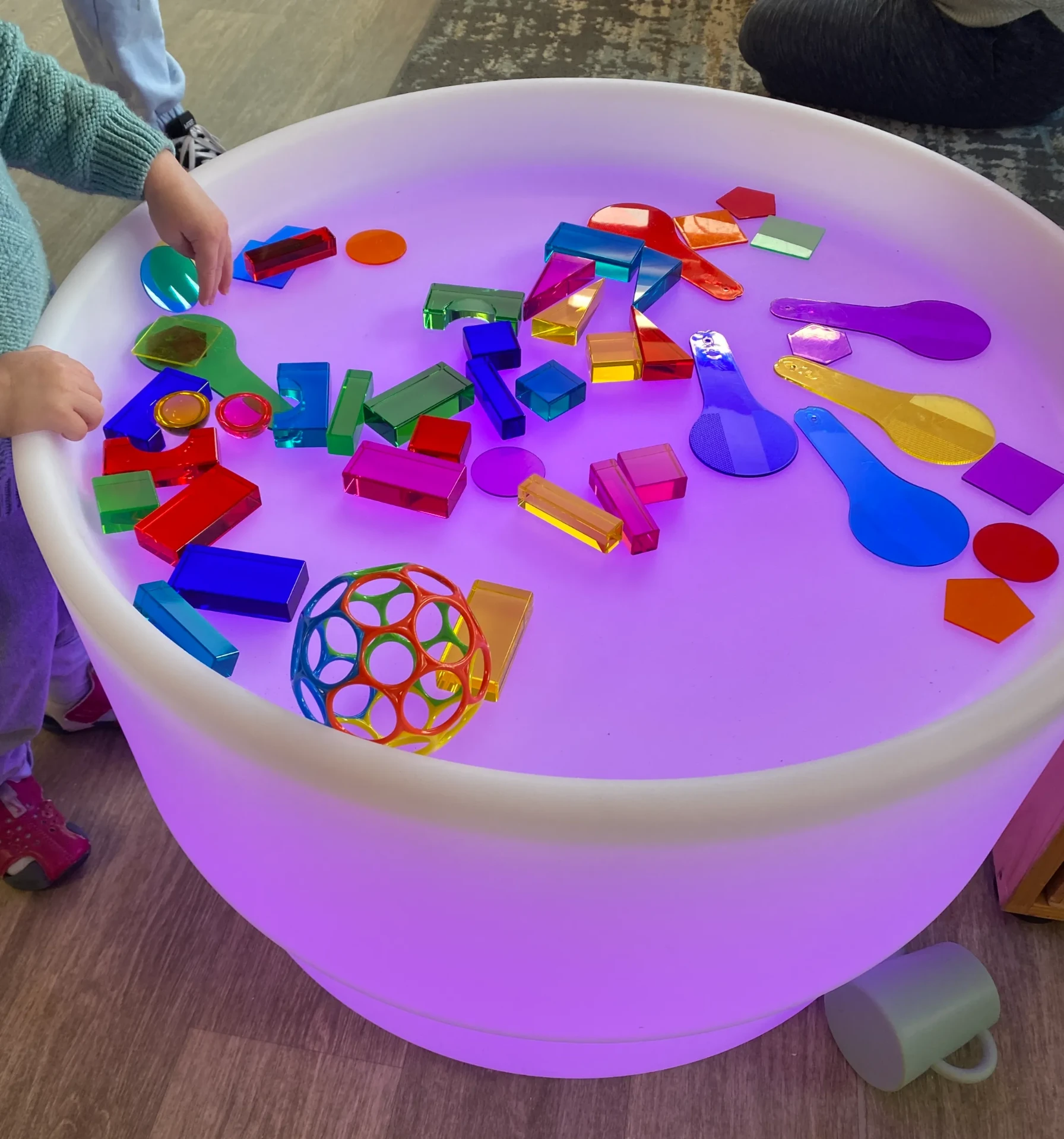 The light table glowing purple with translucent shapes arranged on top
