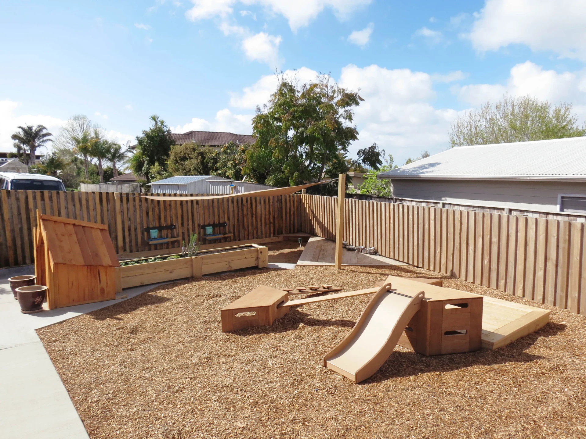 Natural playground with bark chip, wooden ramps and raised garden beds